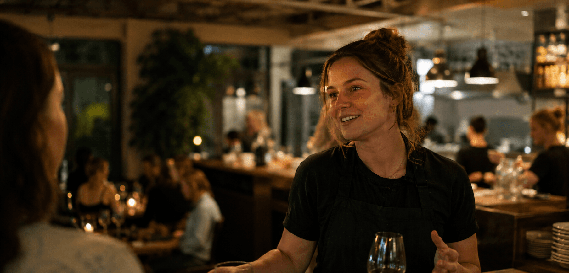 A bar supervisor talking with a guest during service